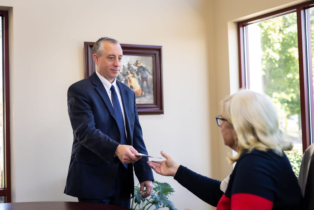 Christopher Sharry handing paper to client